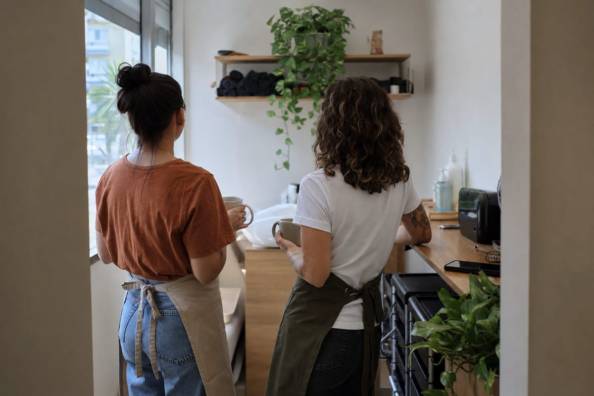 Duas cabeleireiras fazendo uma pausa para o café nos fundos do salão